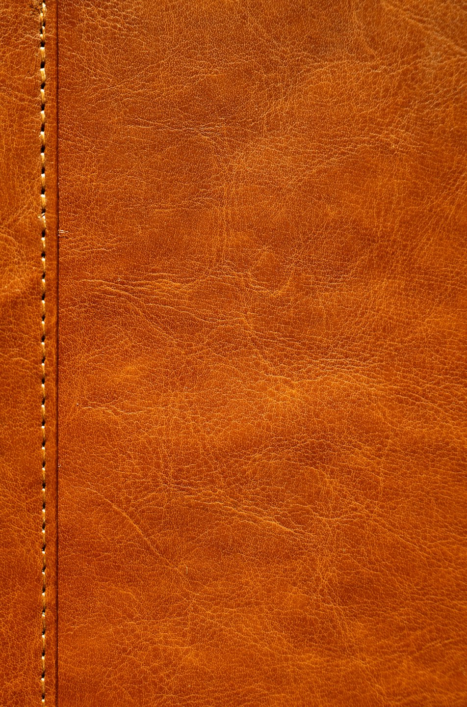 Texture di pelle marrone con una linea verticale di cuciture.